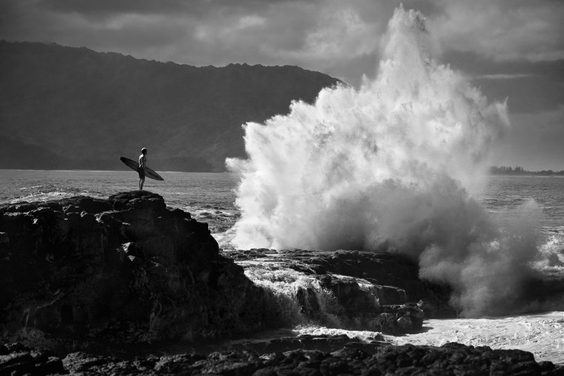 Surfer Laird Hamilton am Felsen in Kauai, Hawaii vor einer Welle 